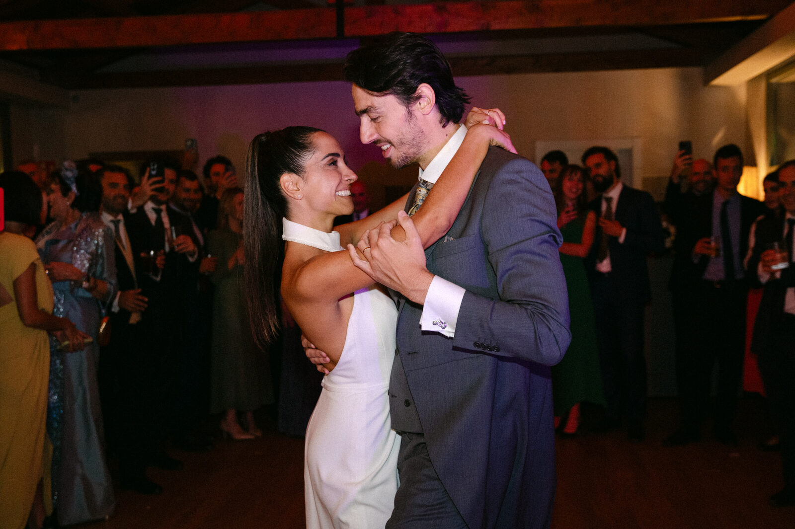 Fiesta con luces cálidas al fondo — boda de Fernanda y Álvaro en Finca Los Calizos, Sierra de Madrid